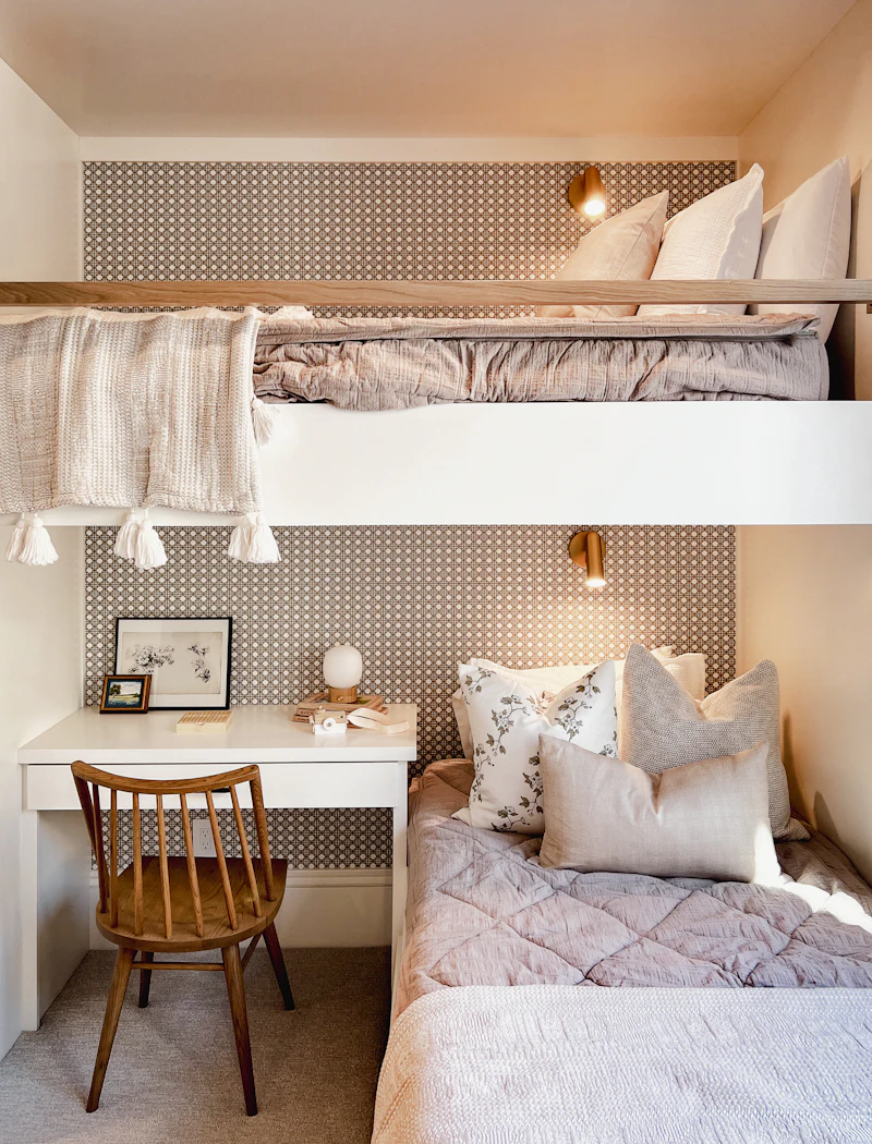 A bright PG room with a bunk bed above a study desk